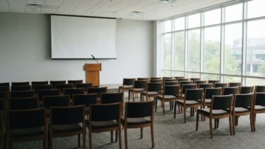 演台とマイクのある明るいセミナー会場